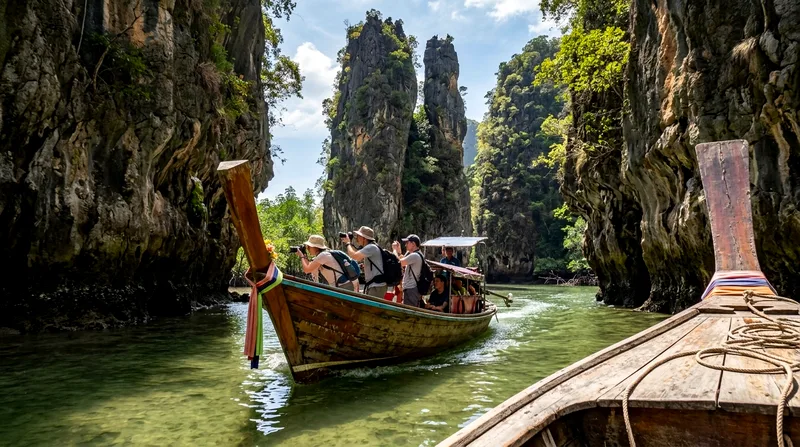 Longtail boat navigating through limestone pillars in Phang Nga Bay.