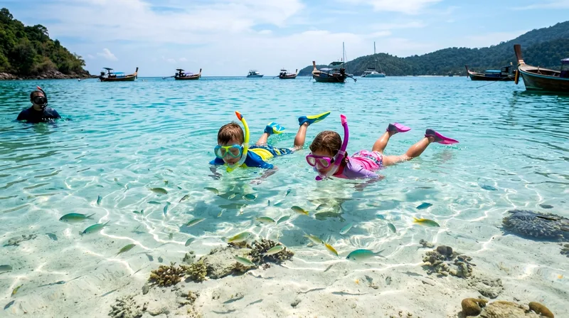 Two young children snorkeling together in shallow cove at Koh Naka Yai